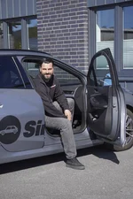 Mitarbeiter der Fahrschule Simonsen sitzt im Fahrschulauto und schaut aus dem Fahrzeug.