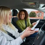 Fahrschülerin erhält nach bestandener Fahrprüfung ihren Führerschein.