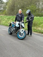 Fahrlehrer erklärt einem Fahrschüler die Funktionen und Technik eines Motorrads.
