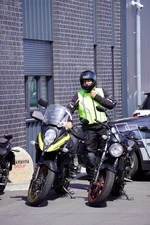 Fahrlehrer steht neben einem Motorrad der Fahrschule Simonsen.